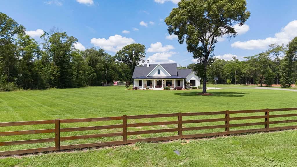 Farmhouse set on open pasture behind a rail fence in Northwest Florida